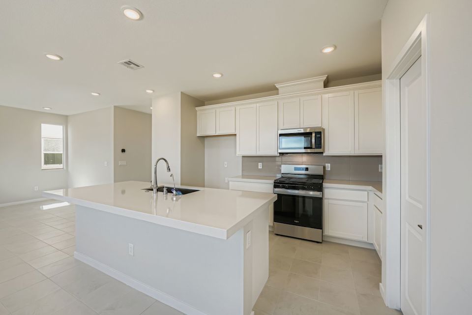 A kitchen with white cabinets.