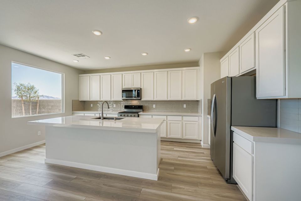 A kitchen with white cabinets.