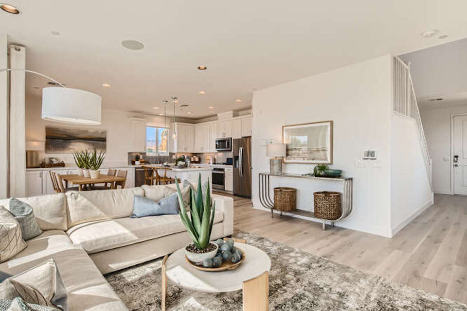 A living room with a large kitchen.