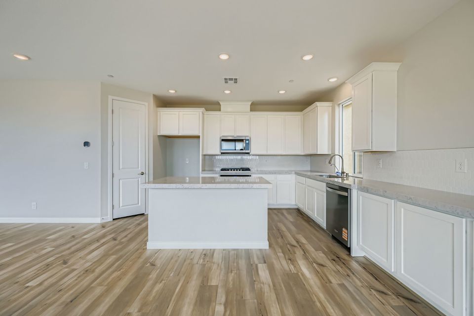 A kitchen with white cabinets.