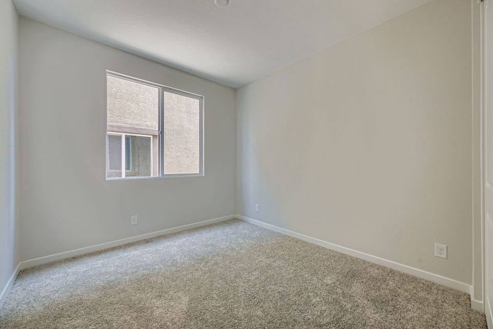A room with a carpet and a window.