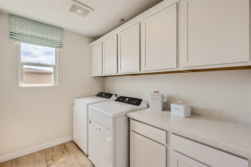 A kitchen with white cabinets.