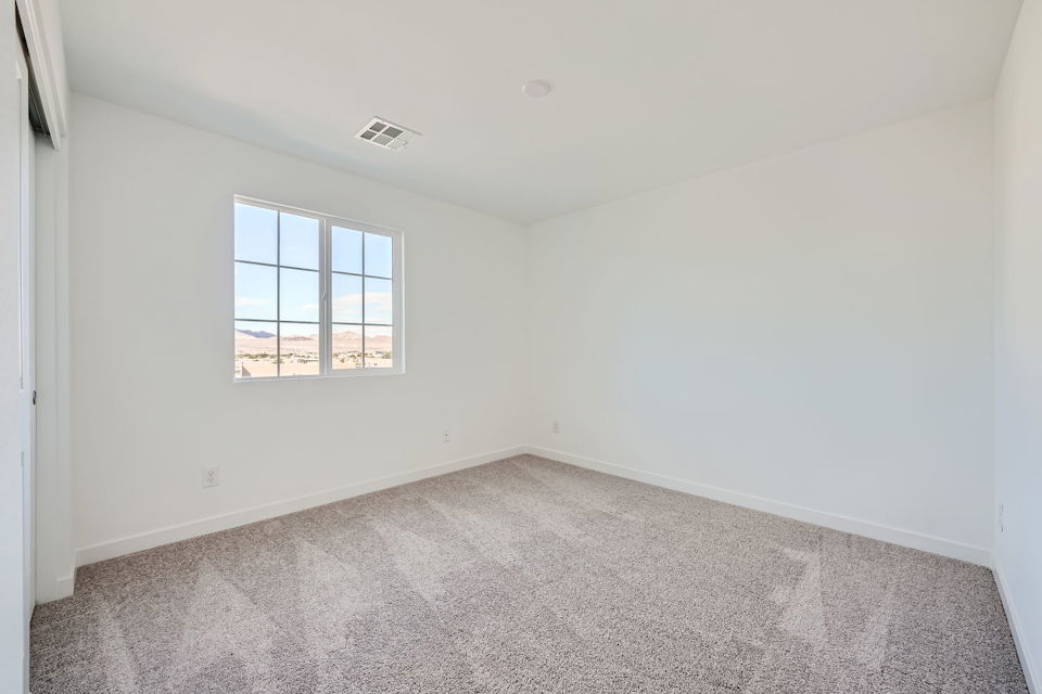 A room with a window and a carpet.