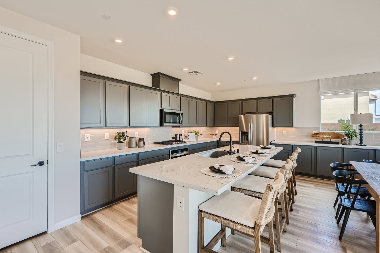 A kitchen with a bar and chairs.