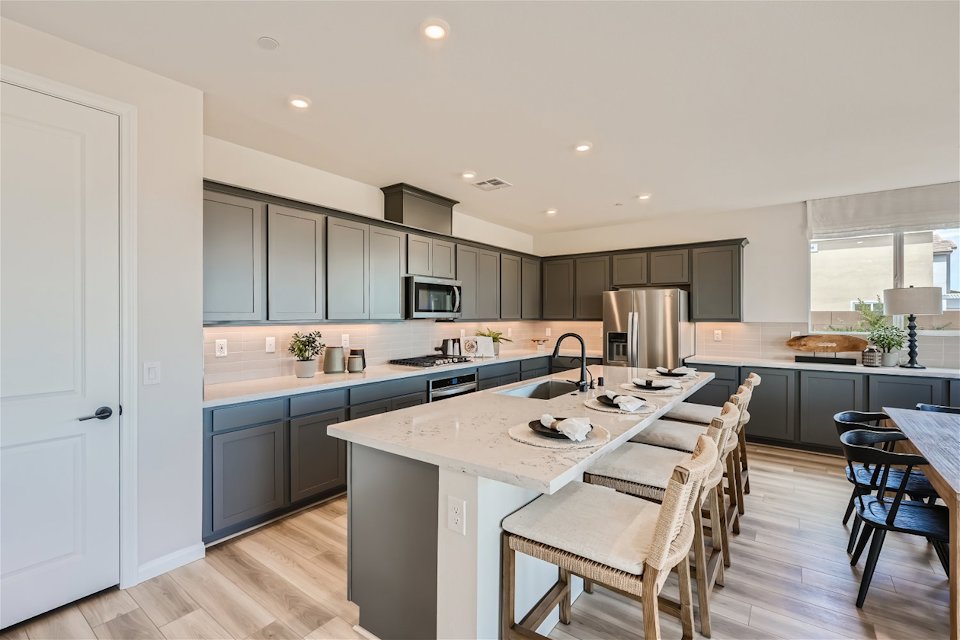 A kitchen with a bar and chairs.