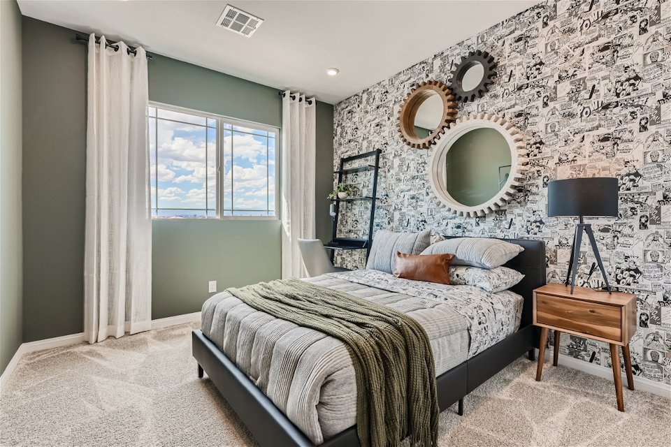 A bedroom with a bed and a lamp.