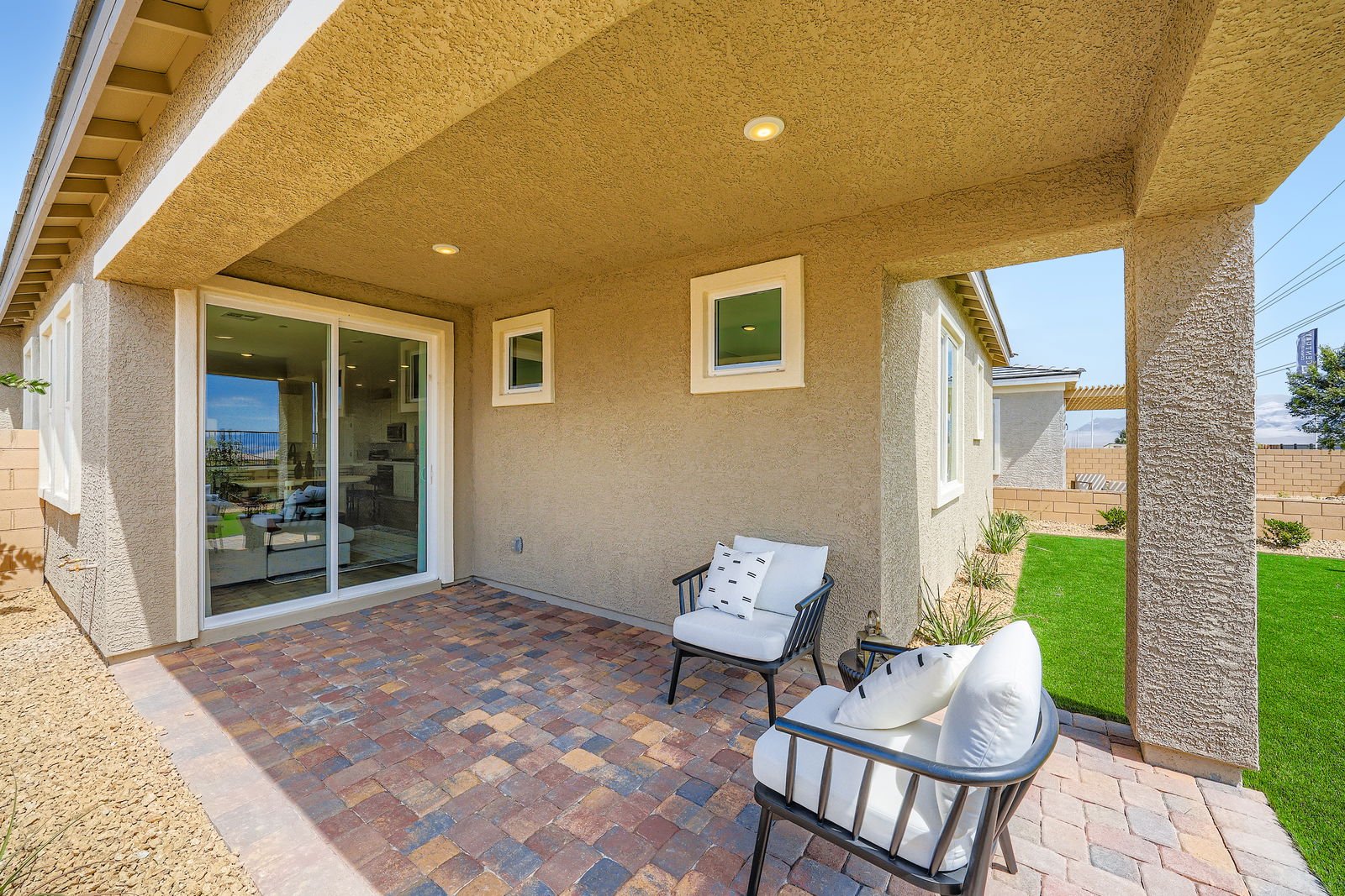 A patio with chairs and a glass door.