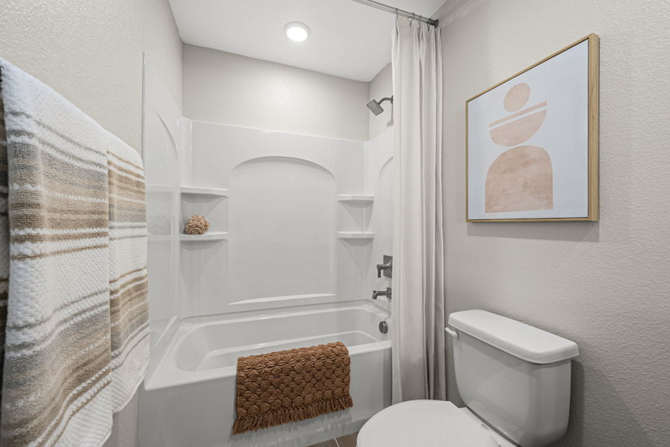 A bathroom with a bathtub and toilet.