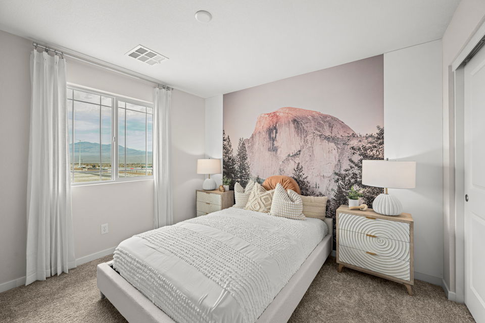 A bedroom with a bed and a lamp.