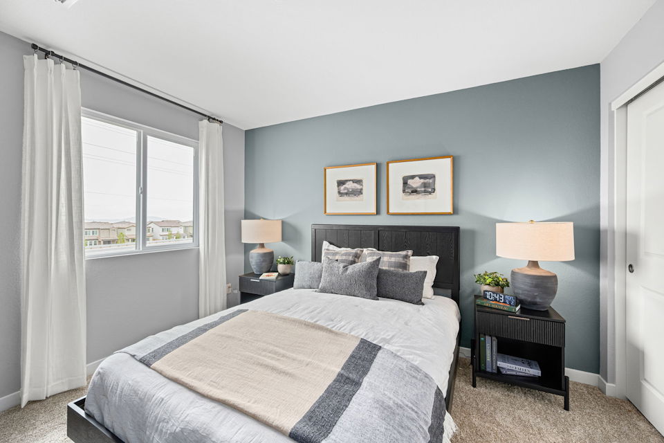 A bedroom with a bed and a window.