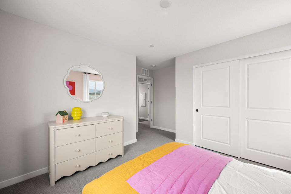 A bedroom with white cabinets.