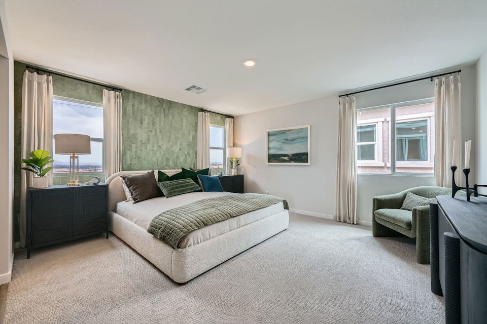 A large bedroom with a couch and a chair.