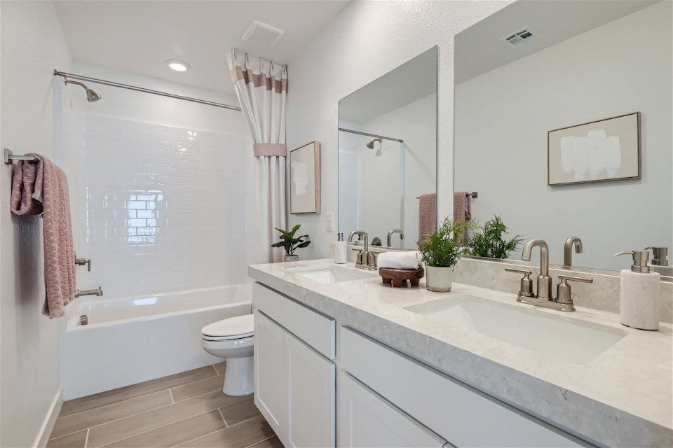 A bathroom with a tub sink and toilet.