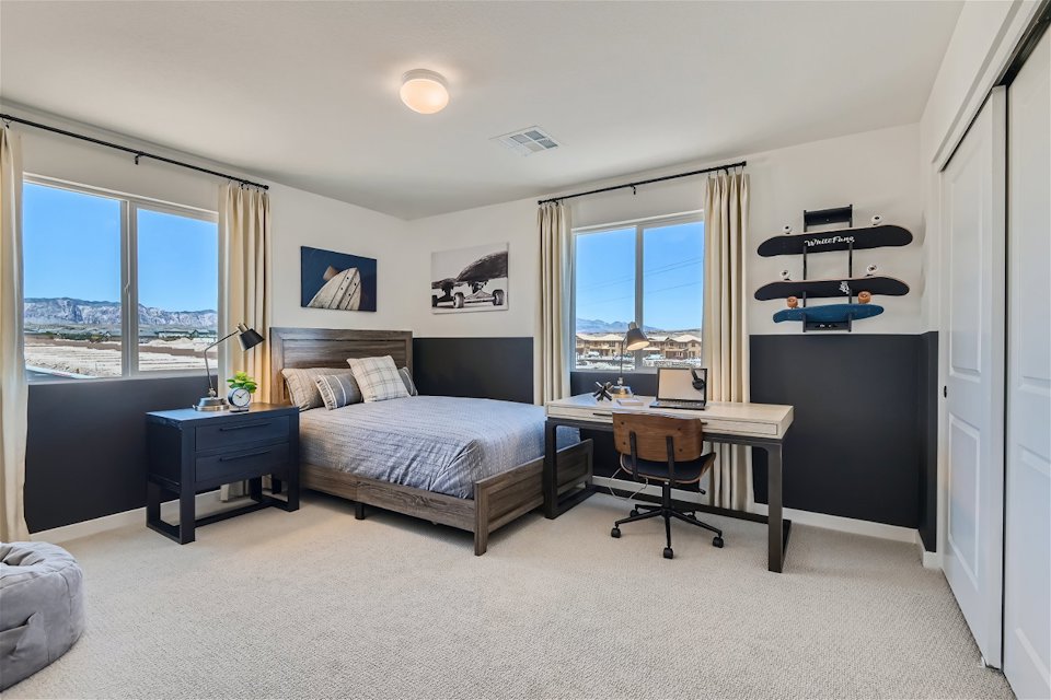 A bedroom with a desk and a chair.