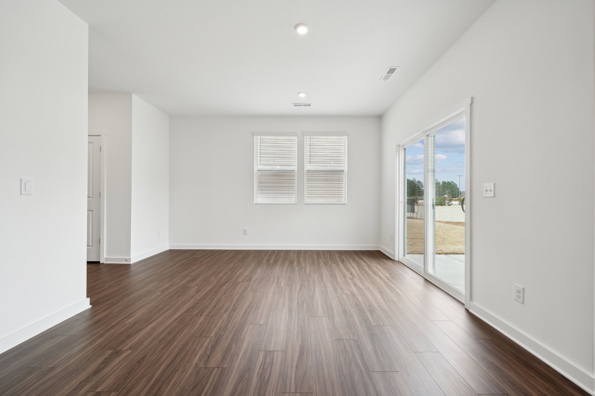 A room with a wood floor and white walls.