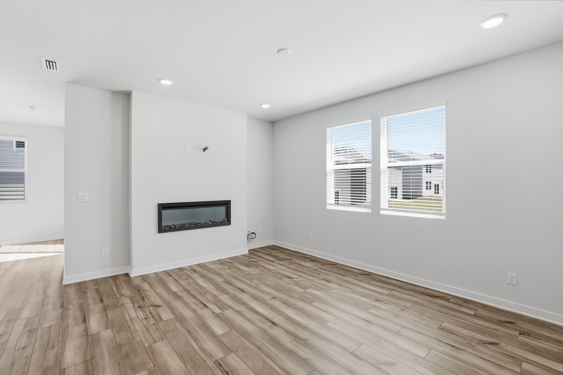A room with a wood floor and white walls.