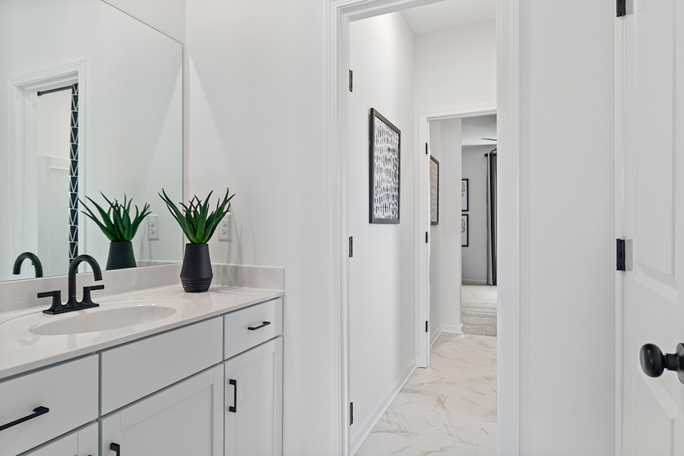 A bathroom with white cabinets.