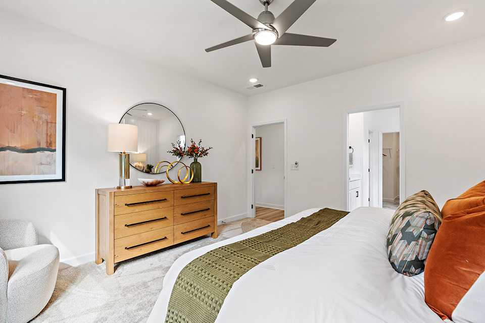 A bedroom with a bed and a fan.