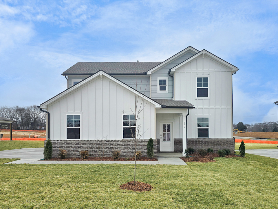 A white house with a lawn.