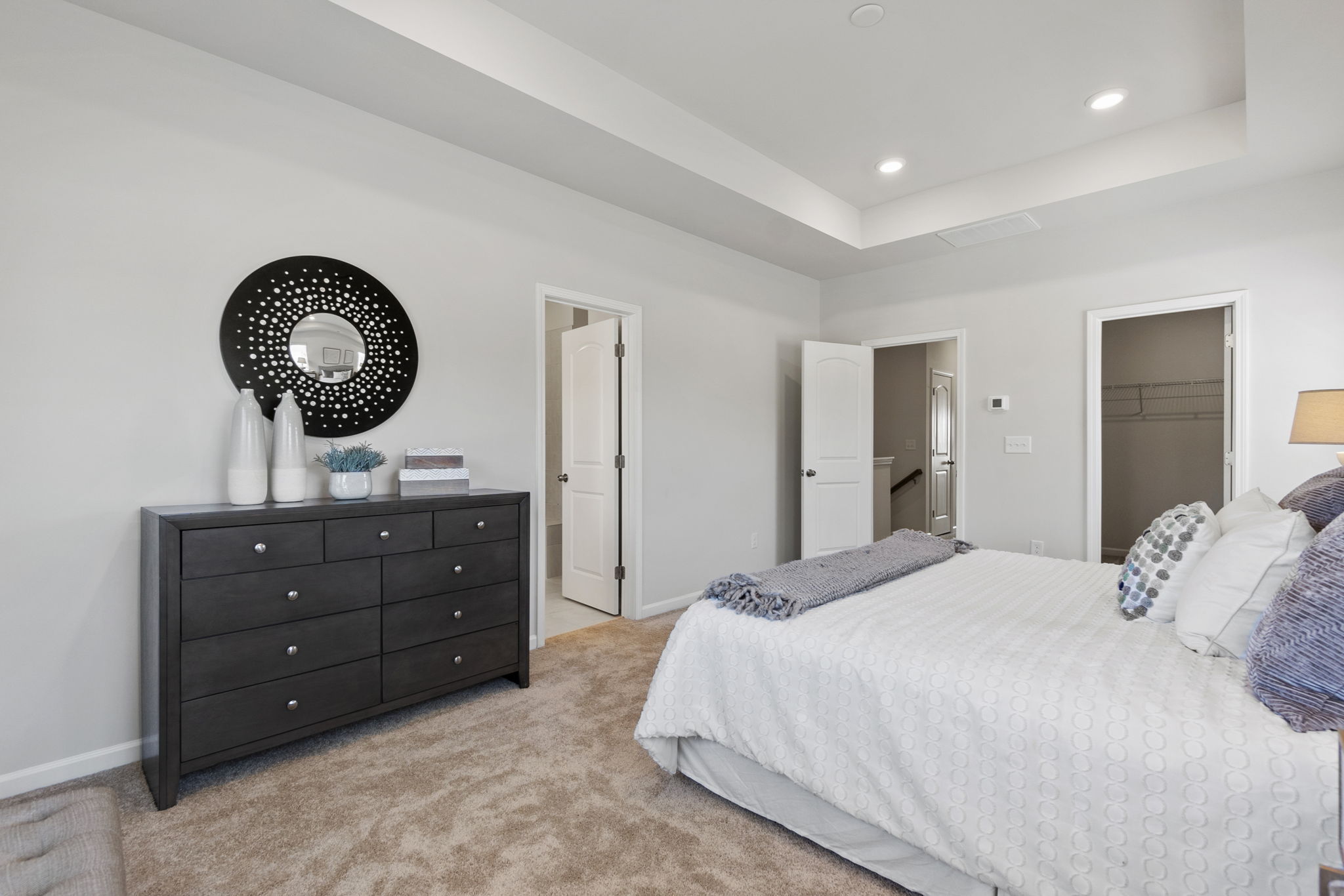 A bedroom with a bed and a mirror.