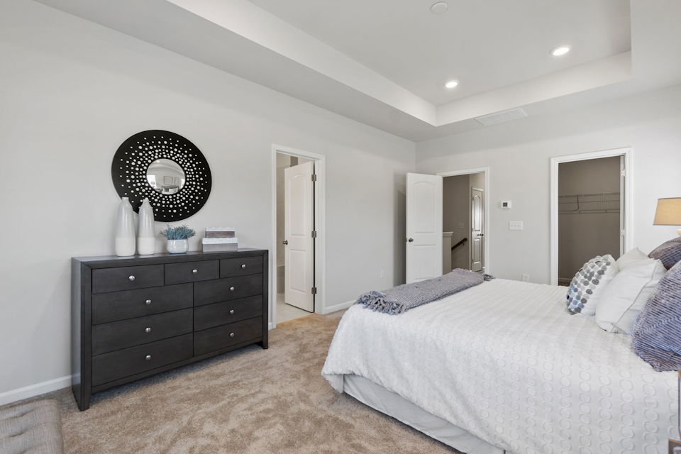 A bedroom with a bed and a mirror.