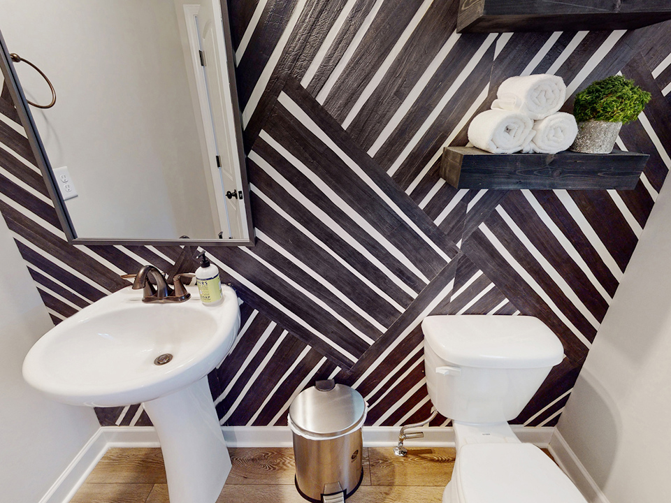 A bathroom with a sink toilet and a mirror.