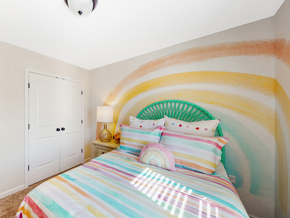 A bed with a colorful bed spread.