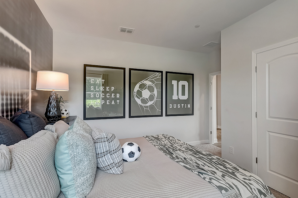 A bedroom with a bed and a lamp.