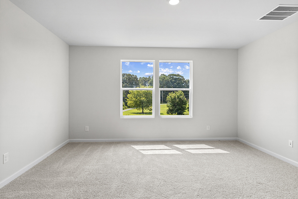 A room with a window and a rug in it.