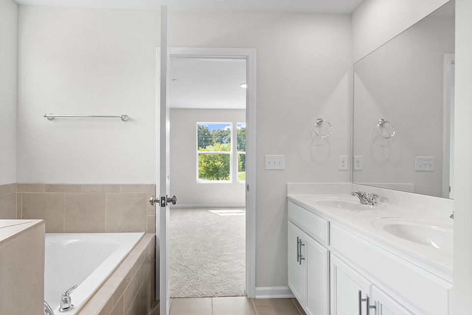 A bathroom with a tub sink and a shower unit.