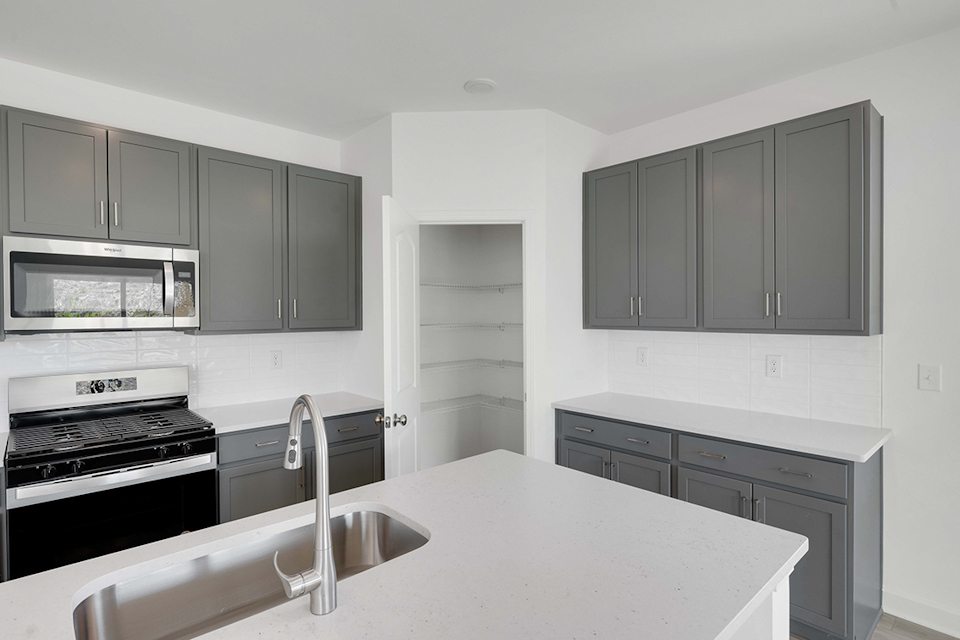 A kitchen with white cabinets.