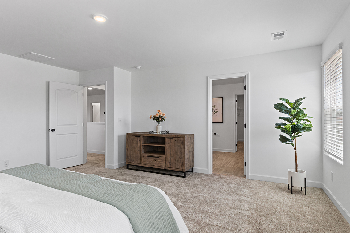 A bedroom with a bed and a dresser.