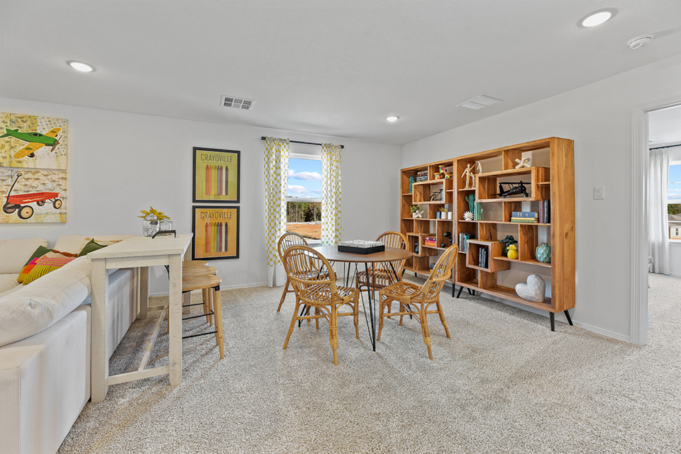 A living room with a table and chairs.