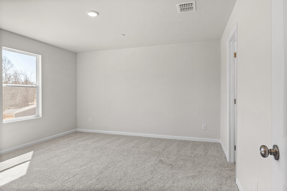 A room with a carpet and a window.