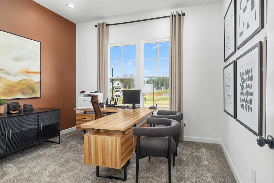 A room with a desk and chairs.