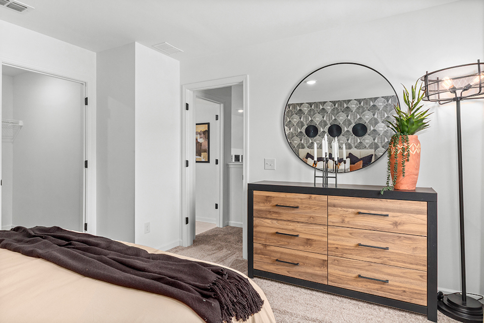 A bedroom with a large mirror.