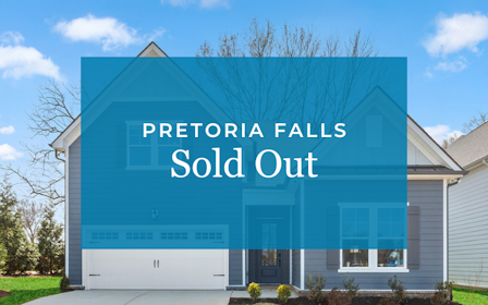 A blue building with a tree in the front.