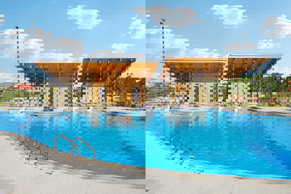 A swimming pool with a building in the background.