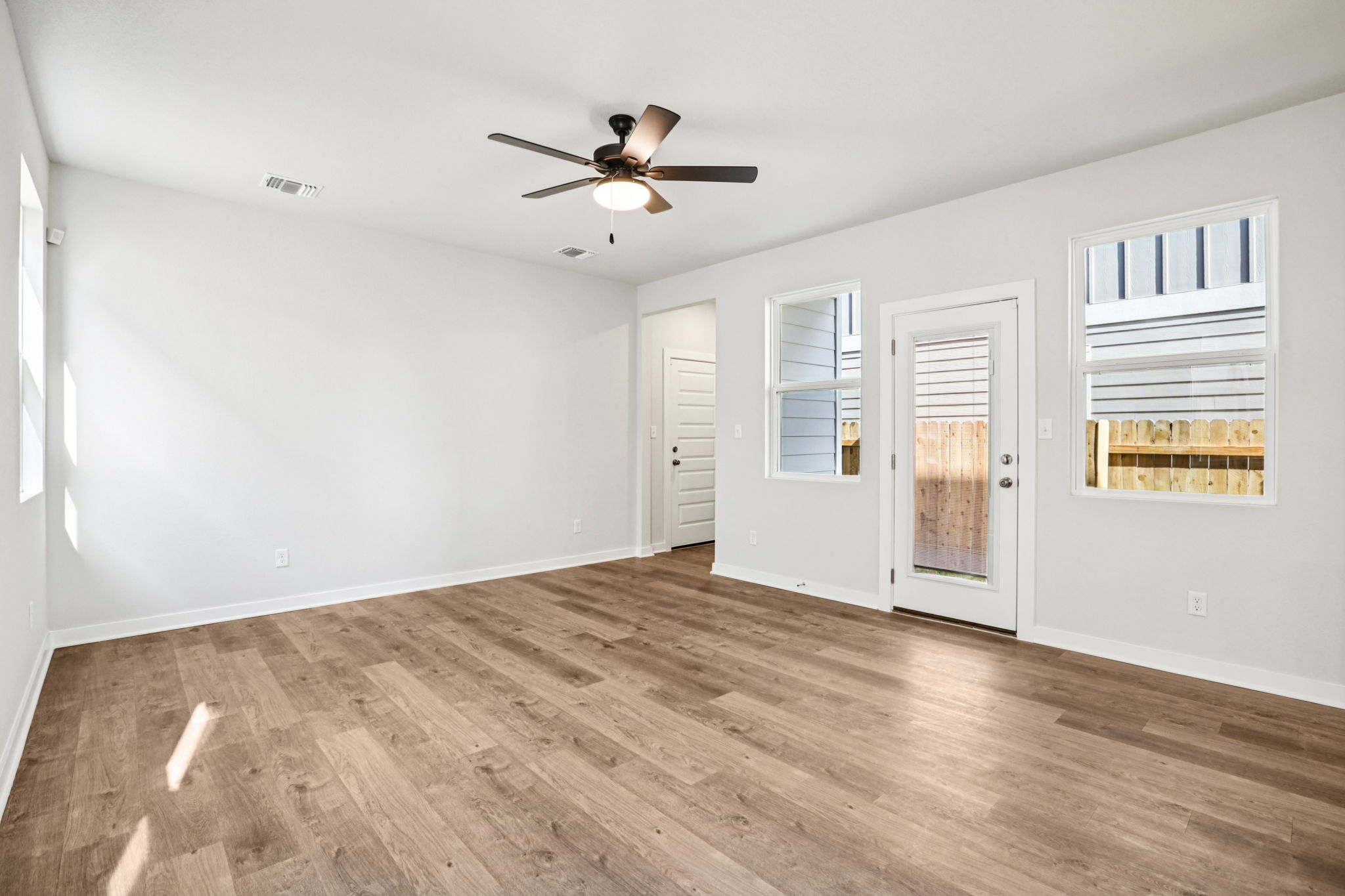 A room with a wood floor and a ceiling fan.