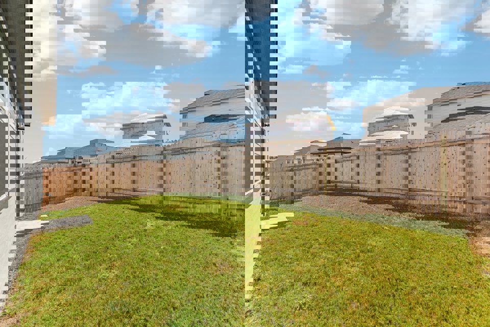 A fenced in yard with a building in the background.