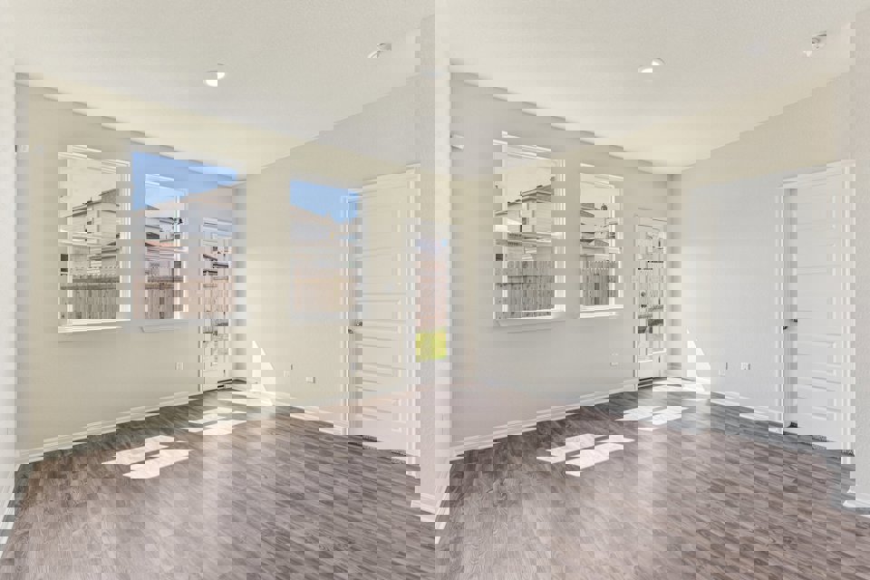 A room with a wood floor and a wood floor with a window.