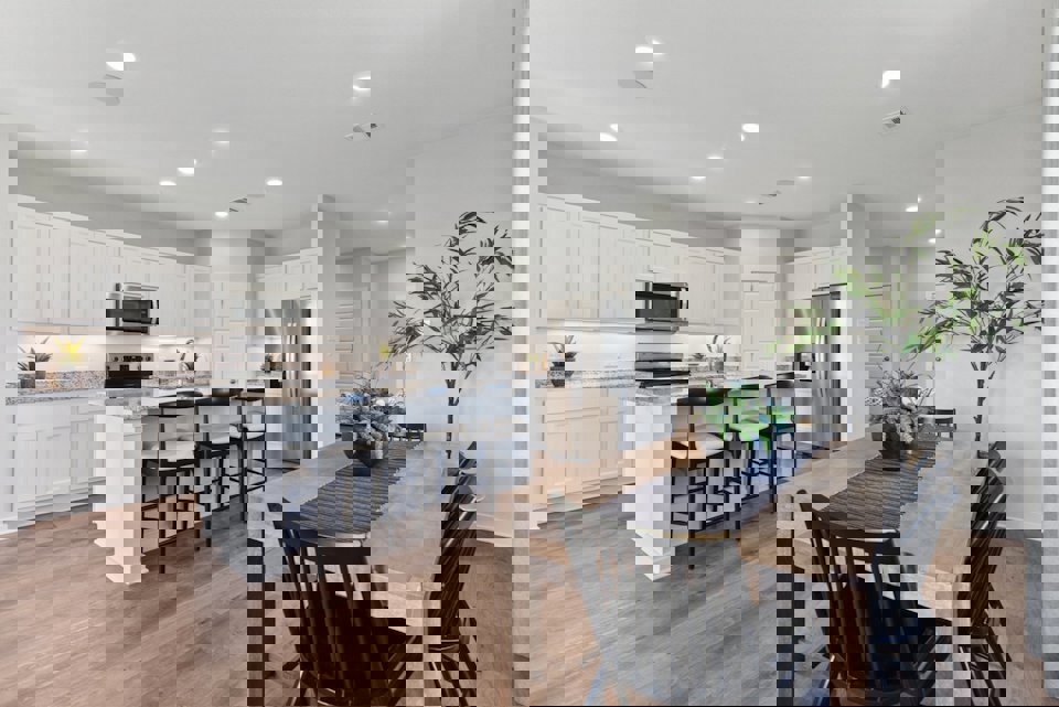 A kitchen with a dining table and chairs.