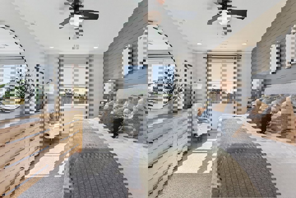 A bedroom with a bed and a fan.