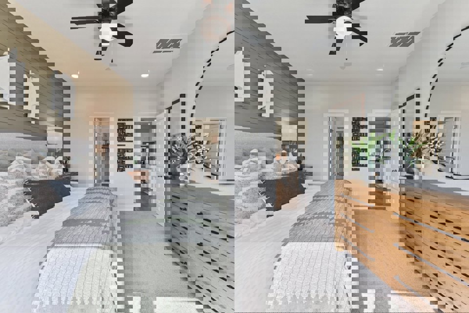 A bedroom with a bed and a fan.