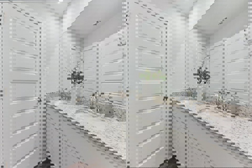 A bathroom with white cabinets.