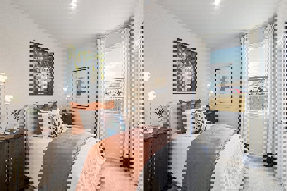 A bedroom with a large window.