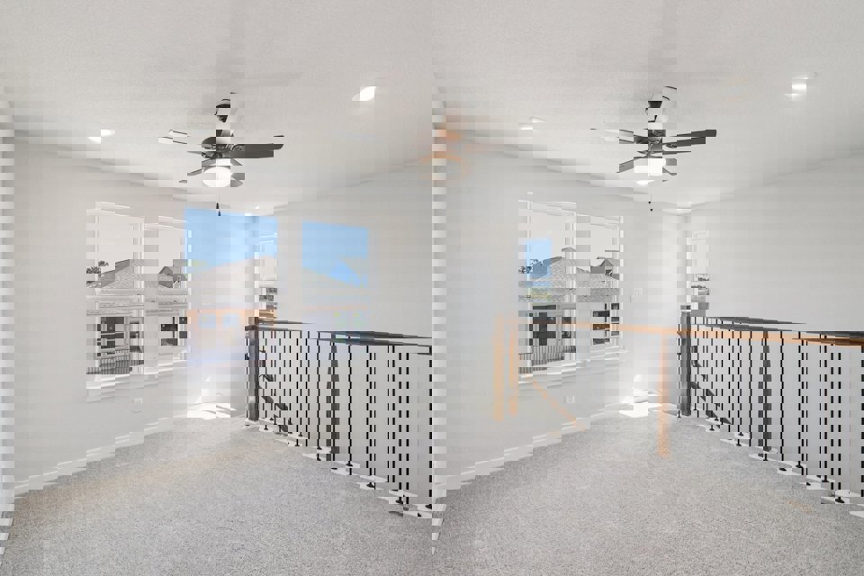 A room with a ceiling fan and a window.