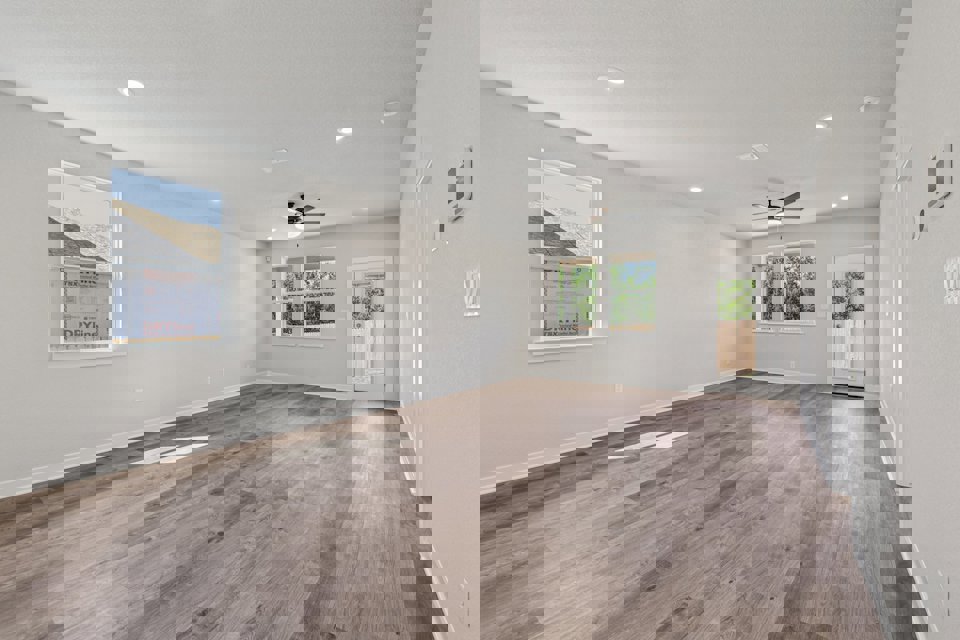 A room with a wood floor and a wood floor with a ceiling fan.