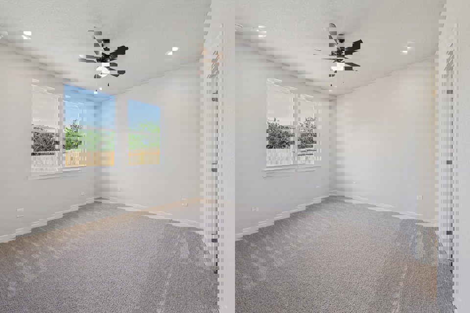 A room with a ceiling fan and a window.