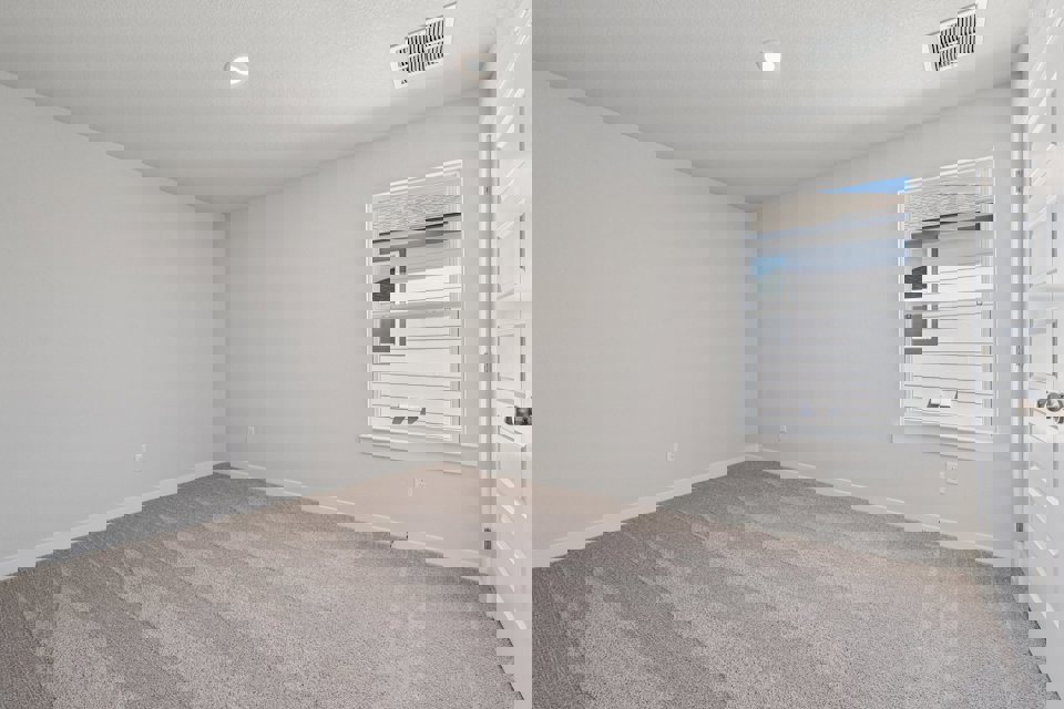 A room with a window and a rug.